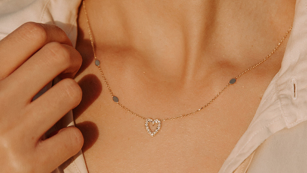 sparkling diamond heart necklace in rose gold on tan model's skin