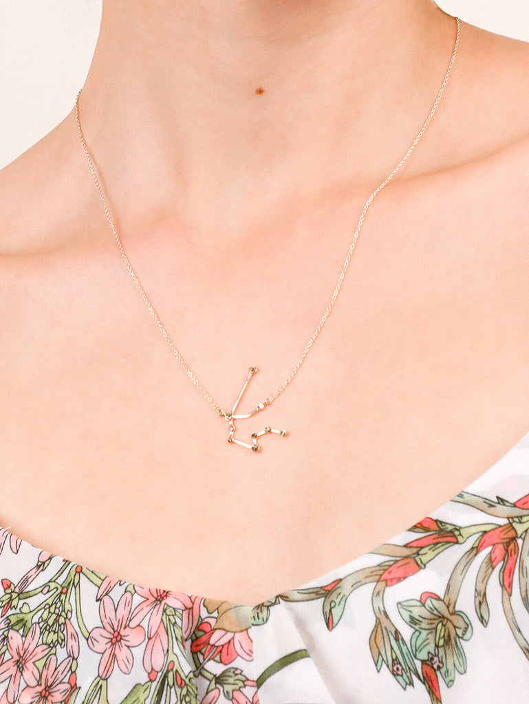 Gold Aquarius Constellation necklace on a female model's neck