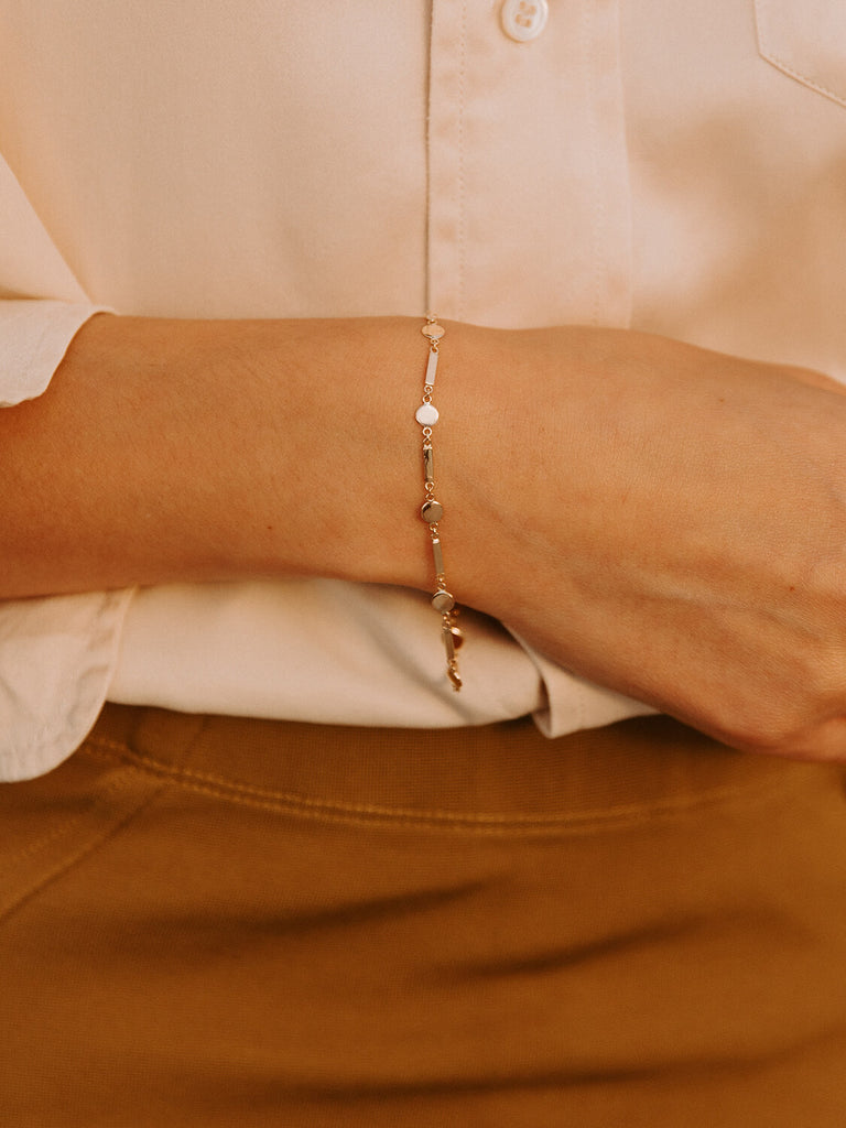 Female model wearing gold Artemis shield bracelet jewelry 