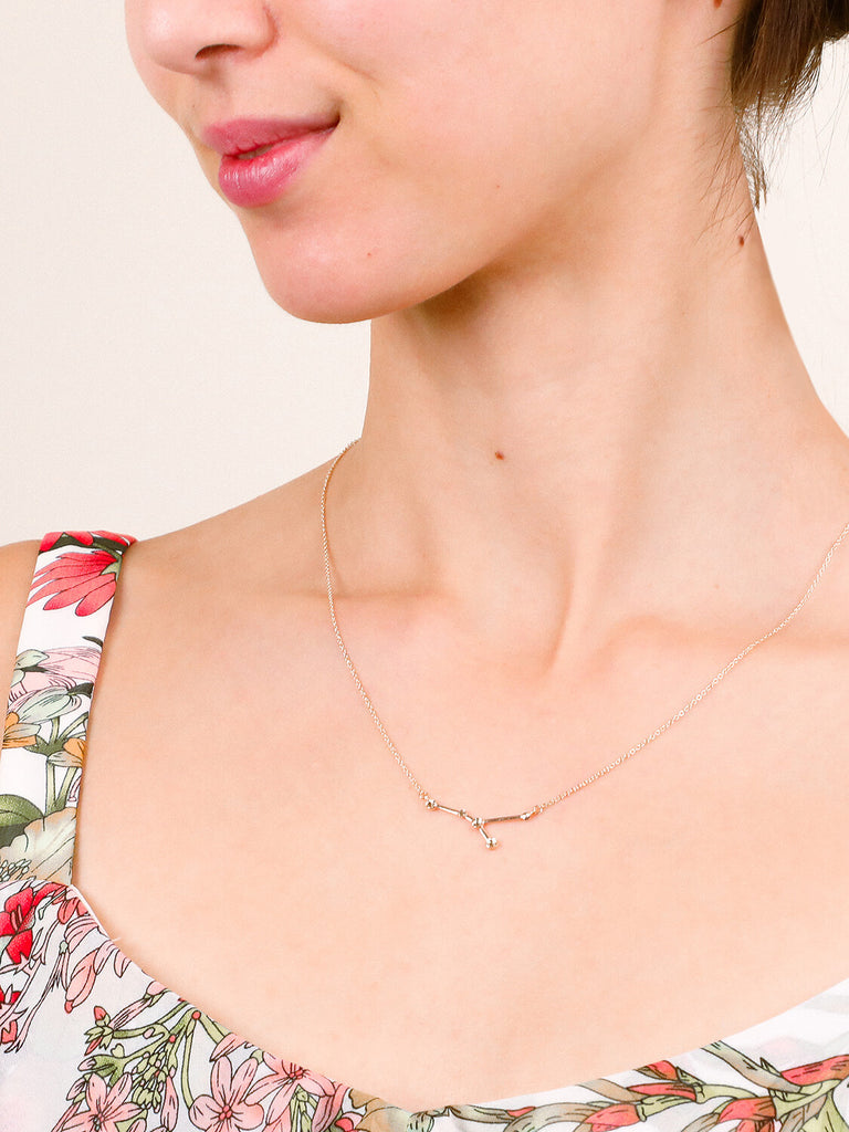 Gold Cancer Constellation necklace on a smiling female model's neck