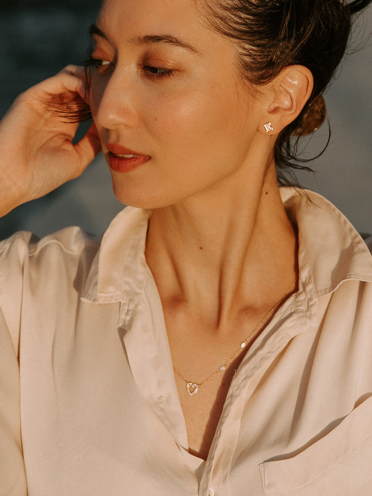 photo of female model wearing a charmed heart necklaces in yellow gold during golden hour