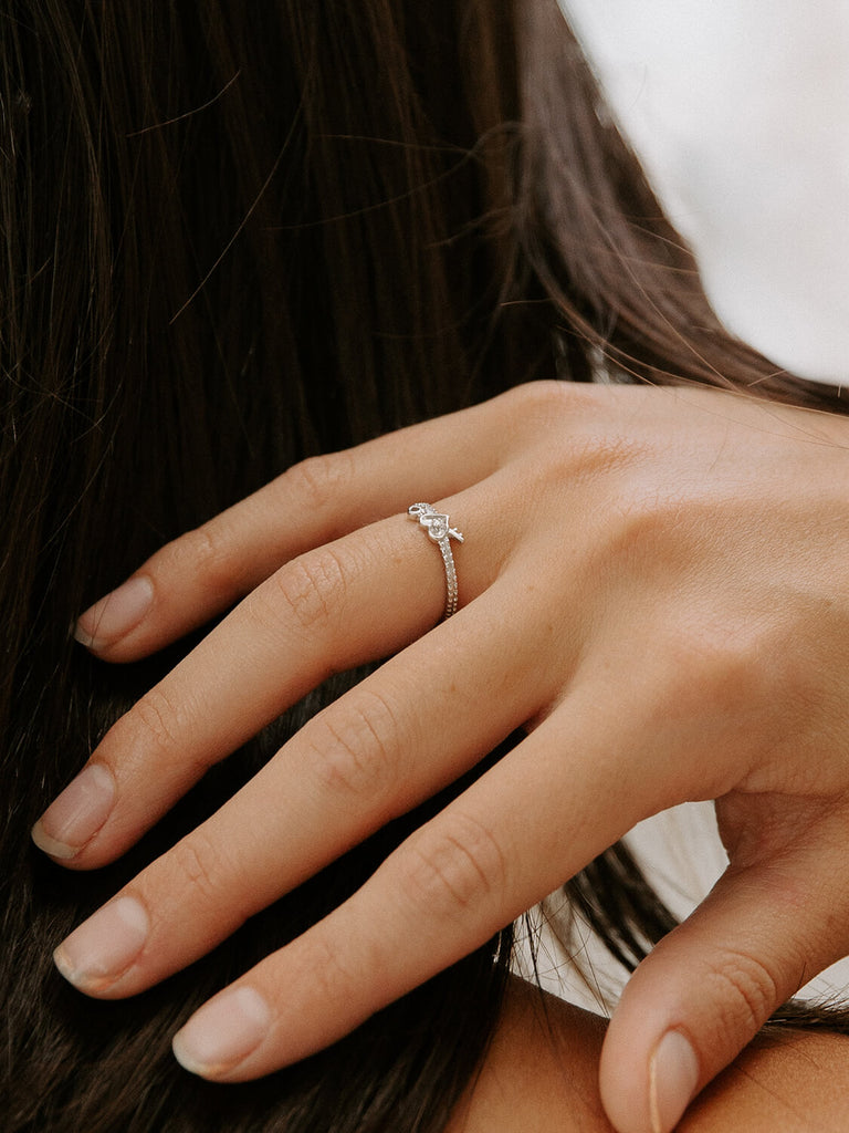 detail photo of woman's diamond love locked ring in 14k white gold on female model's hand