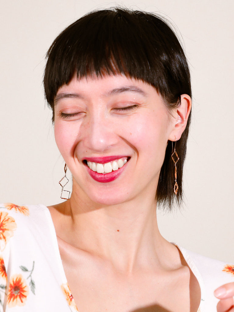 laughing female model wearing Halo rectangle stacked earrings looking at the camera