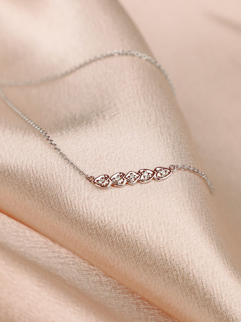 detail photo of heart bar necklace with diamond against in 14k white gold