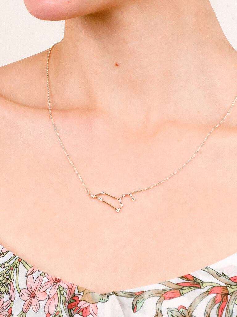 Gold Leo Constellation necklace on a female model's neck