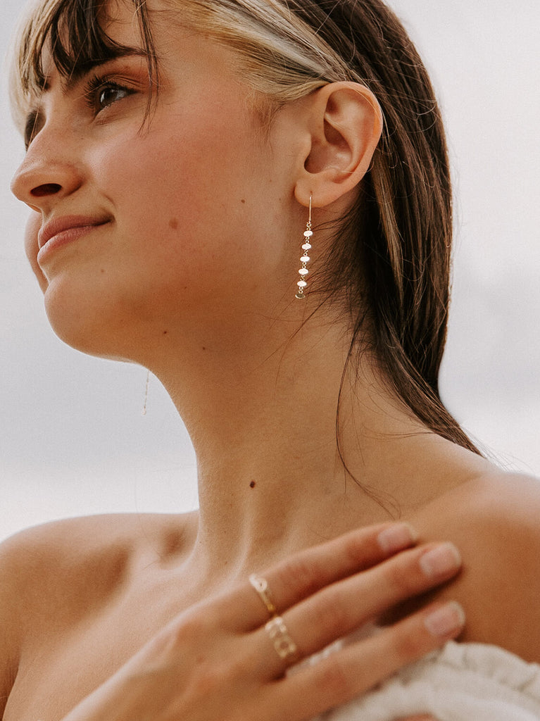 happy female model wearing mermaid's beauty oval earrings looking at the camera