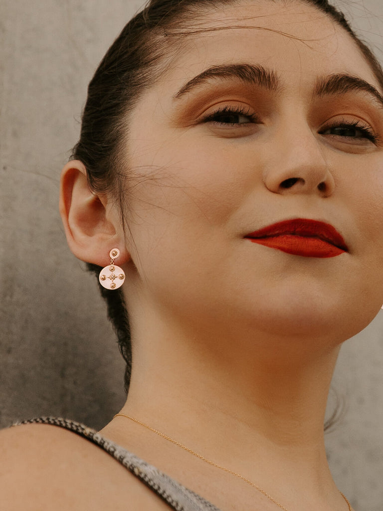 Female model wearing Midnight Celestial Earrings in rose gold with red lipstick