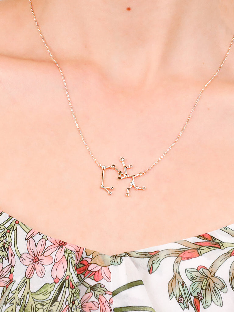 detail shot of Gold Sagittarius Constellation necklace on a female model's neck