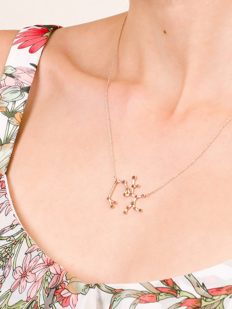 Gold Sagittarius Constellation necklace on a female model's neck