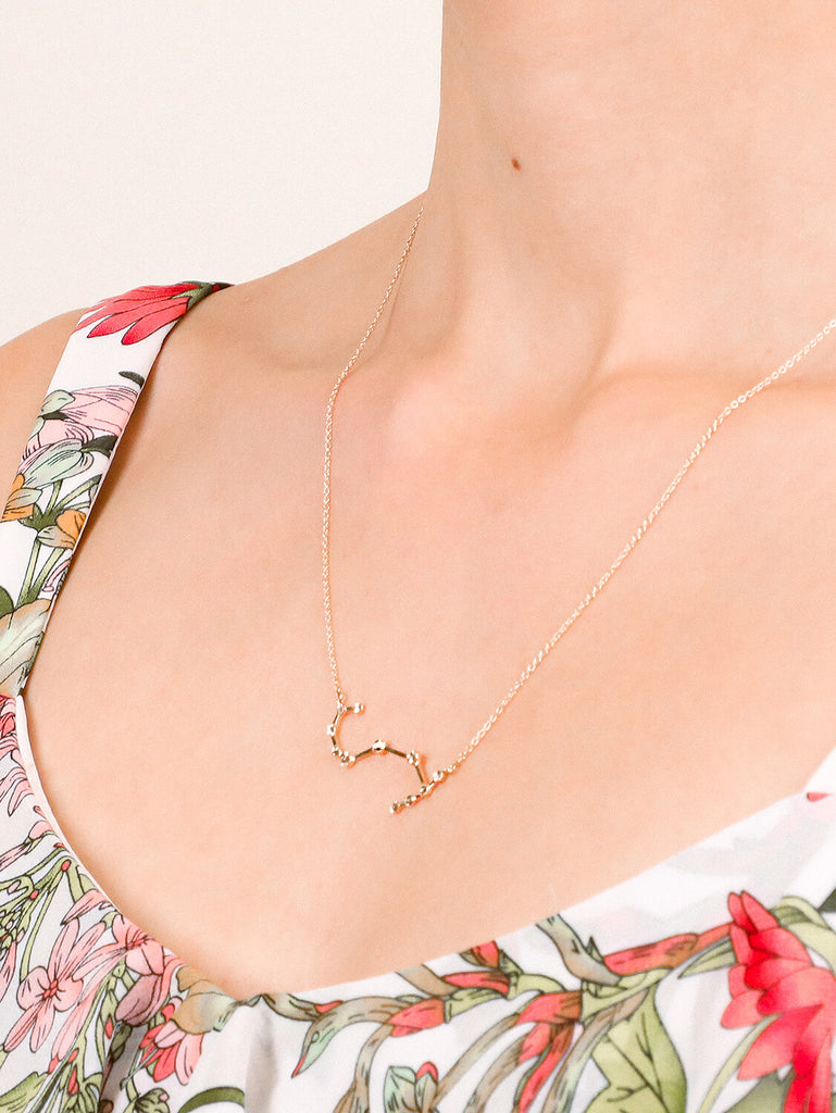 Gold Scorpio Constellation necklace on a female model's neck