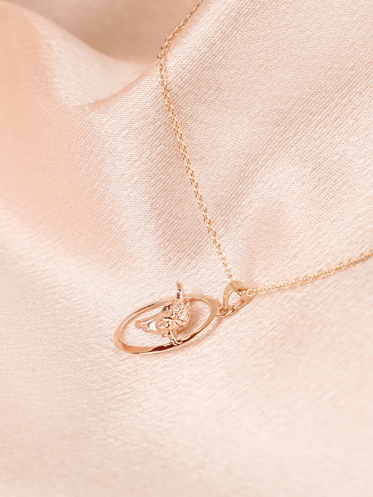 detail photo of taurus zodiac charm necklace with diamonds in 14k yellow gold