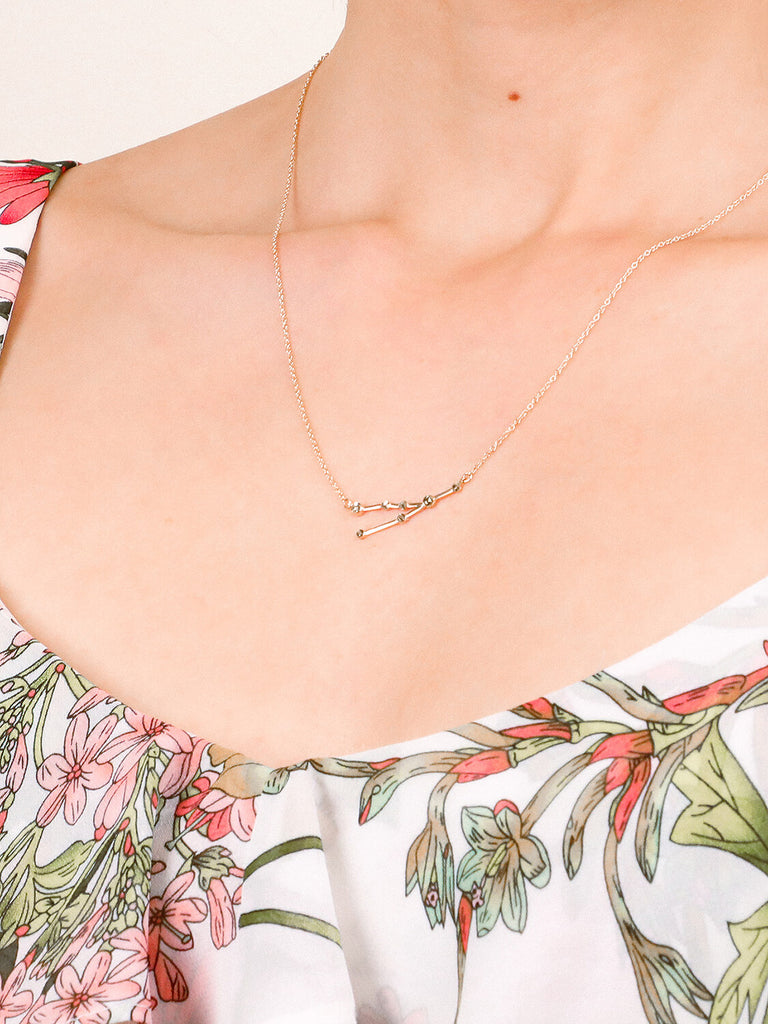 Gold Taurus Constellation necklace on a female model's neck