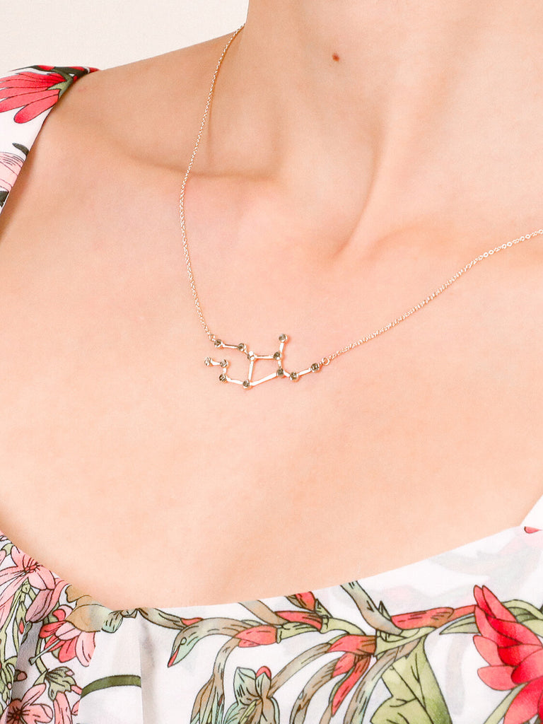 Gold Virgo Constellation necklace on a female model's neck