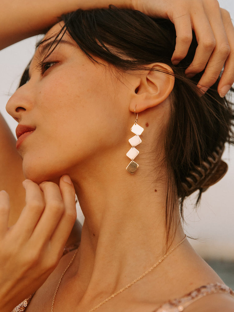 gold Artemis plate earrings on a model who is looking to the side