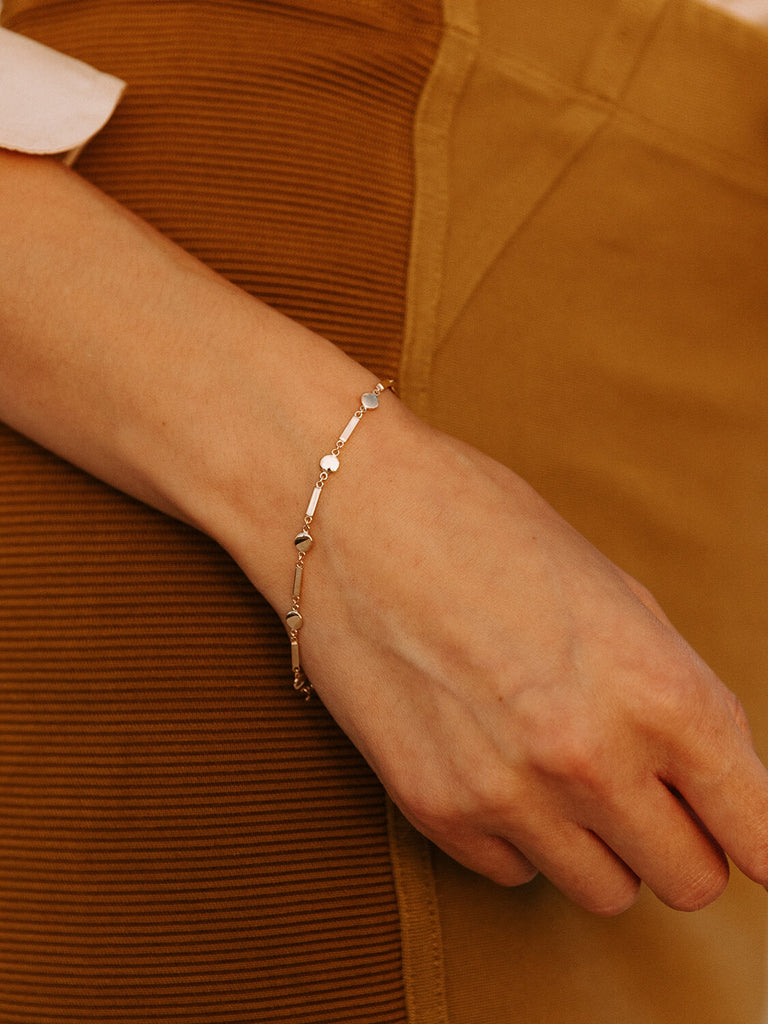 Female model wearing gold Artemis shield bracelet jewelry 