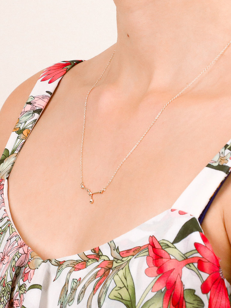 close up Gold cancer Constellation necklace on a female model's neck