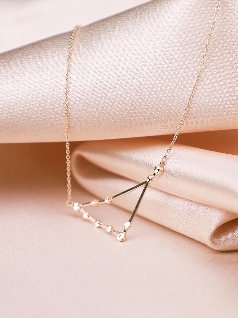 close up of Capricorn constellation necklace laying against satin