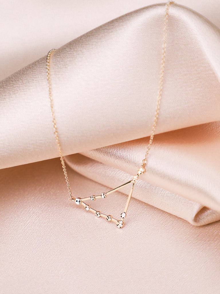 close up of Capricorn constellation necklace against satin