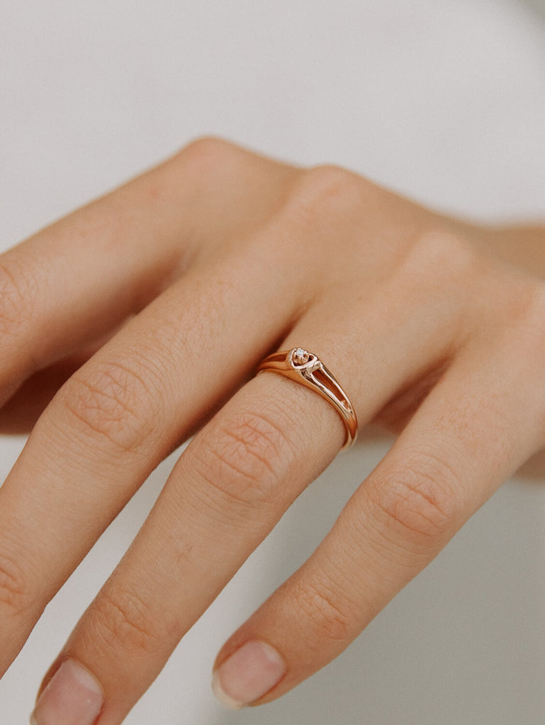 close up shot of diamond heart promise ring in 14k rose gold on female woman model