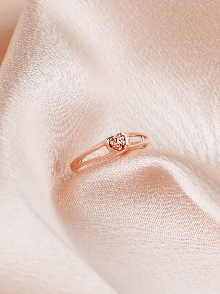 Angled detail shot of diamond heart promise ring in 14k rose gold
