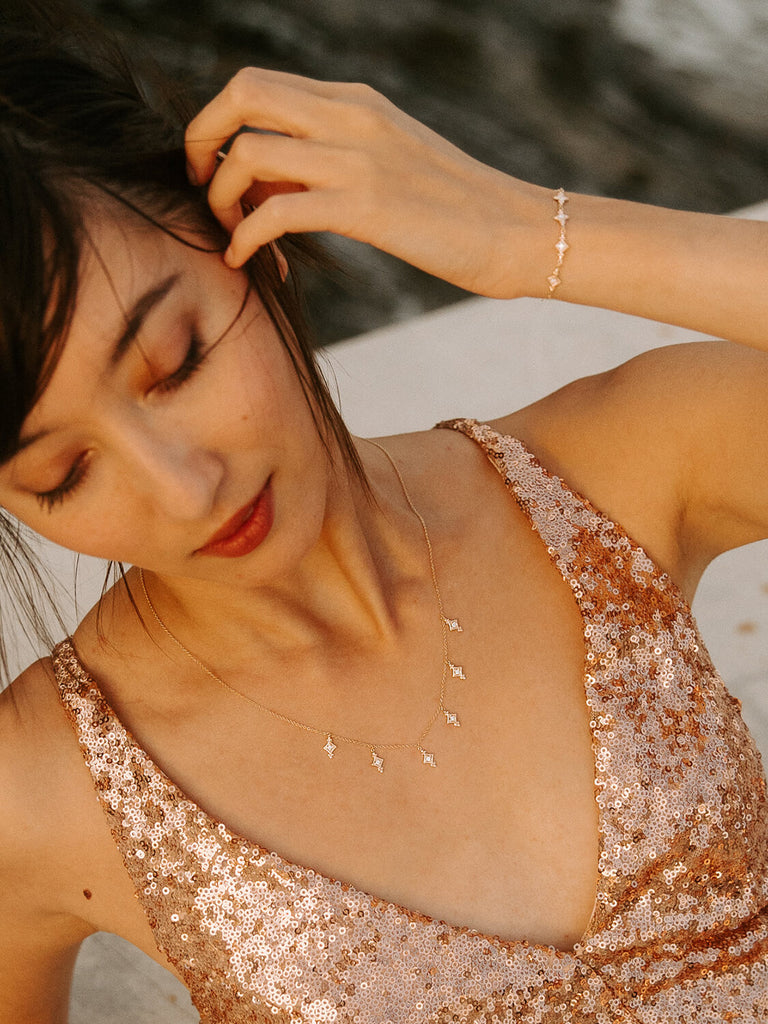 gold evening star bracelet and necklace on a female model in sequin dress