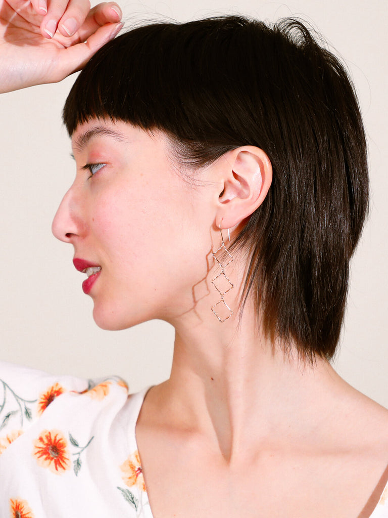 model wearing Halo rectangle stacked earrings looking to the side