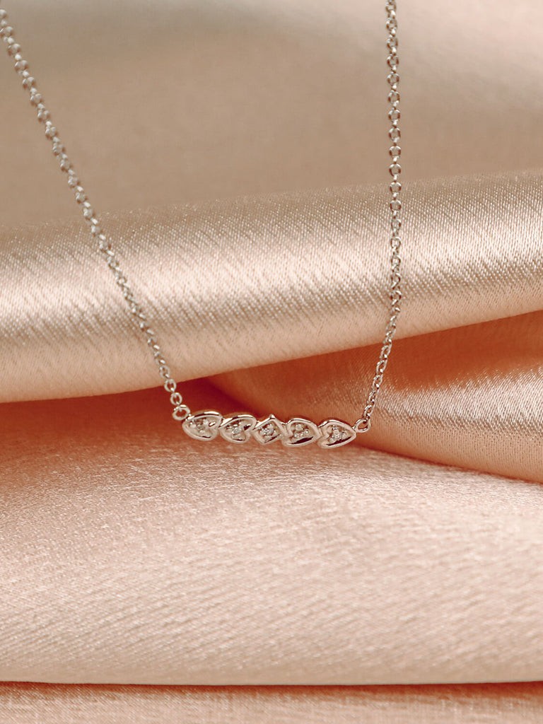 detail photo of heart bar necklace in 14k white gold with diamond in the center