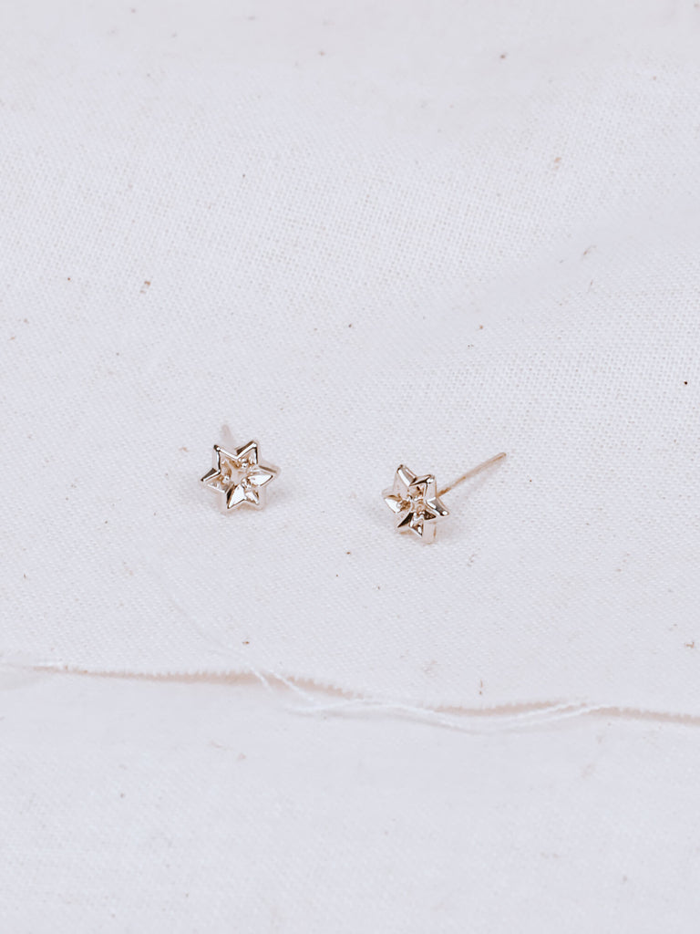 detail shot of midnight star earrings in white gold on fabric