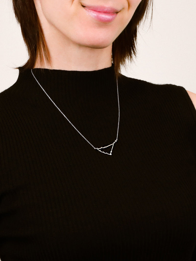 Photo of sterling silver Capricorn zodiac constellation necklace from ModSet jewelry on smiling woman's neck