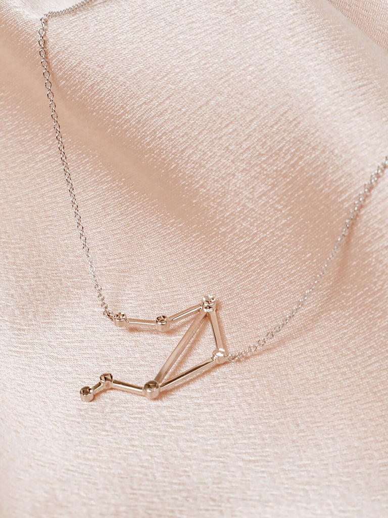 Close detail photo of sterling silver Libra zodiac constellation necklace from ModSet jewelry on pink background