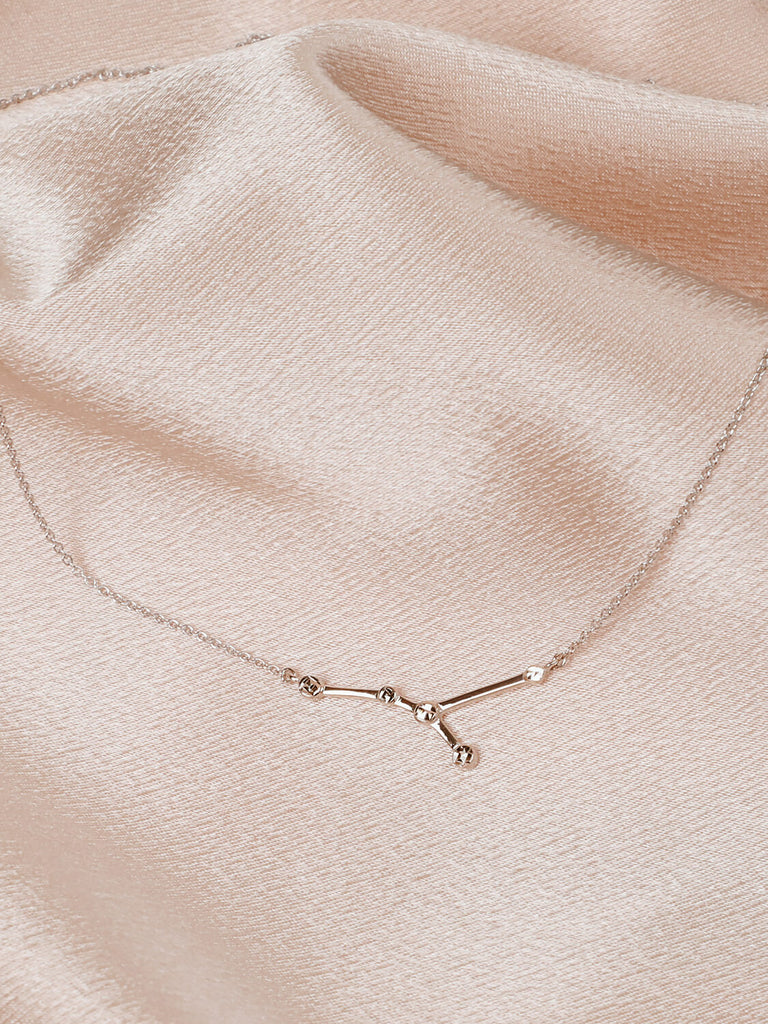 Detail photo of sterling silver Cancer zodiac constellation necklace from ModSet jewelry on pink fabric