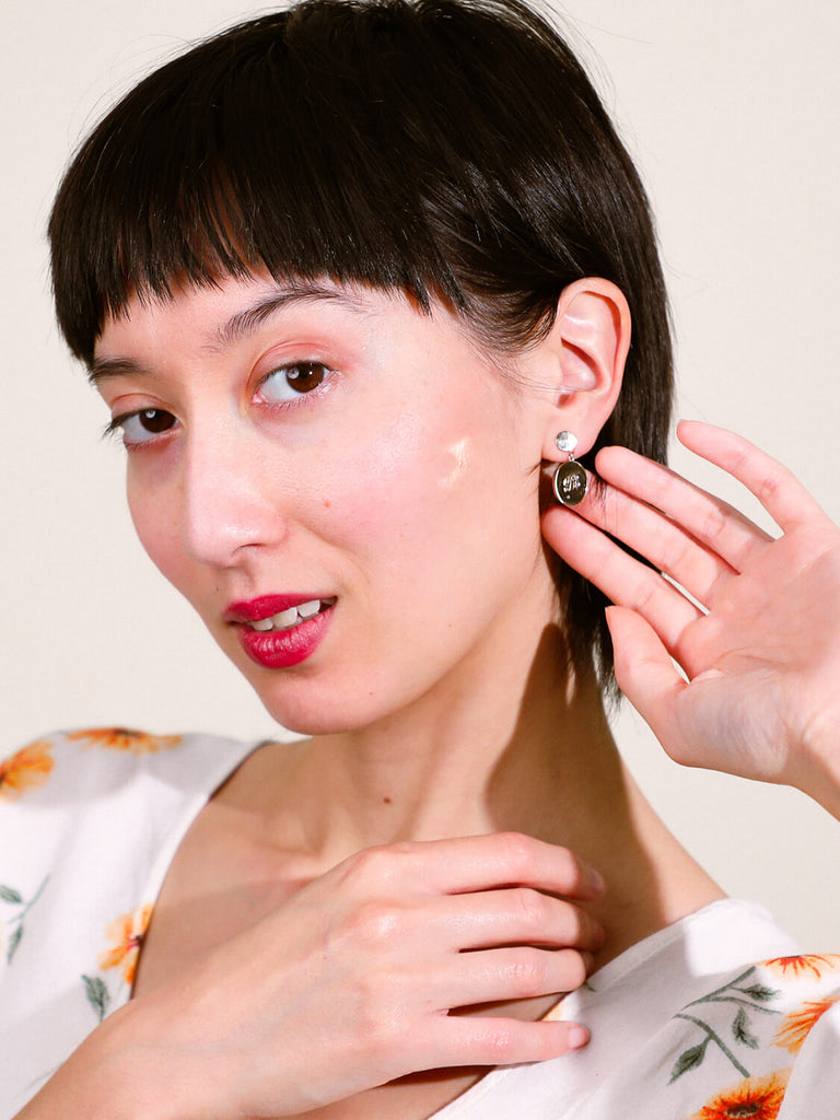 female model wearing "B" Script Monogram post earrings in yellow gold 