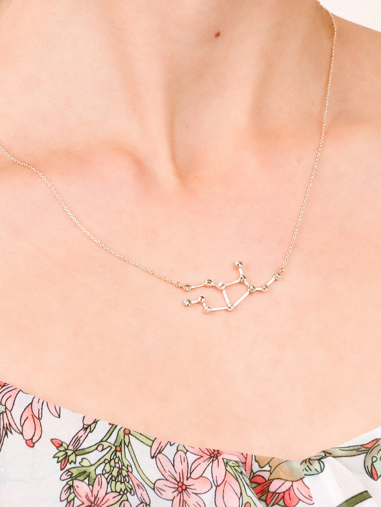 detail of Gold Virgo Constellation necklace on a female model's neck