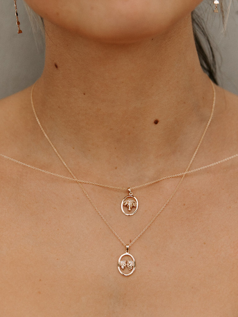 photo of girl model wearing gemini and aries zodiac layered charm pendants necklaces in yellow gold